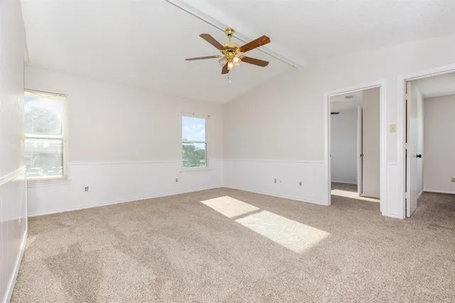 an empty room with window and ceiling fan