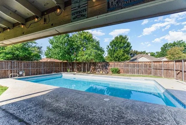 a swimming pool with outdoor seating and yard
