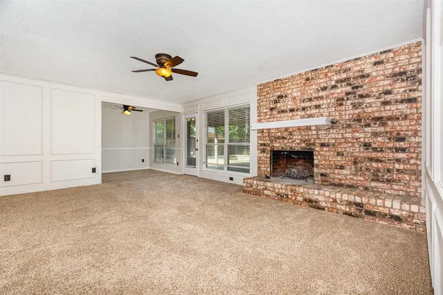 an empty room with fireplace and a window