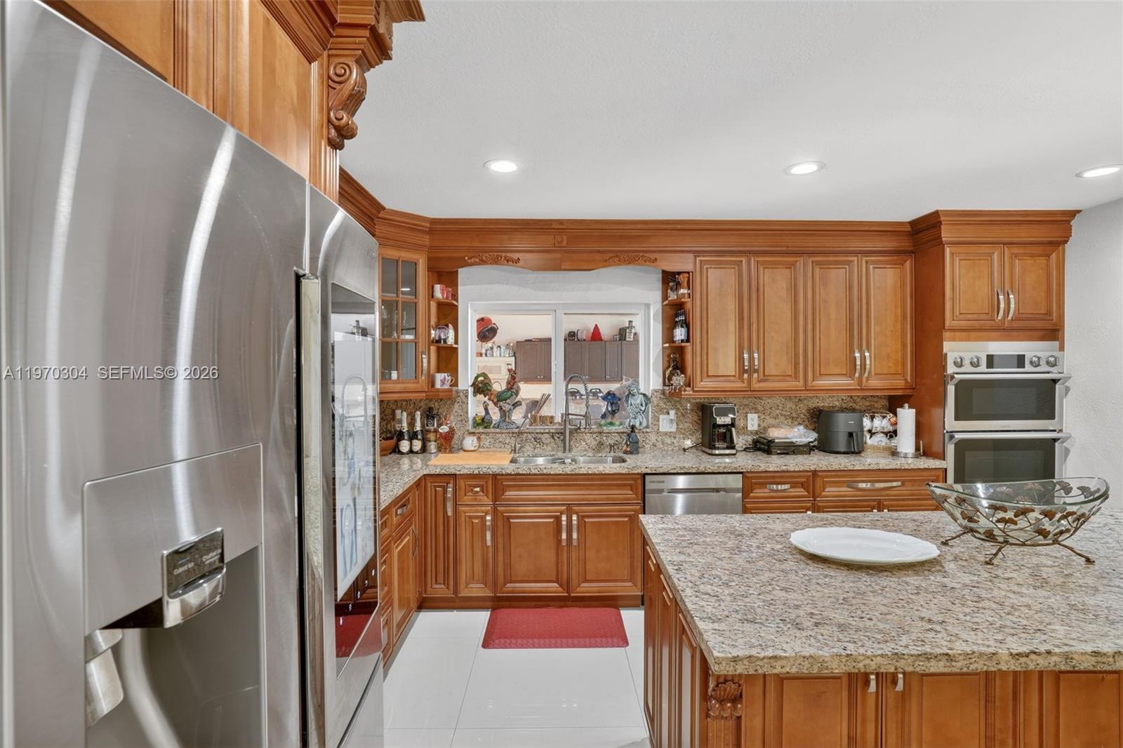 19390 Southwest 312th Street Homestead, FL 33030 - Photo 12 of 44 a kitchen with sink refrigerator and cabinets