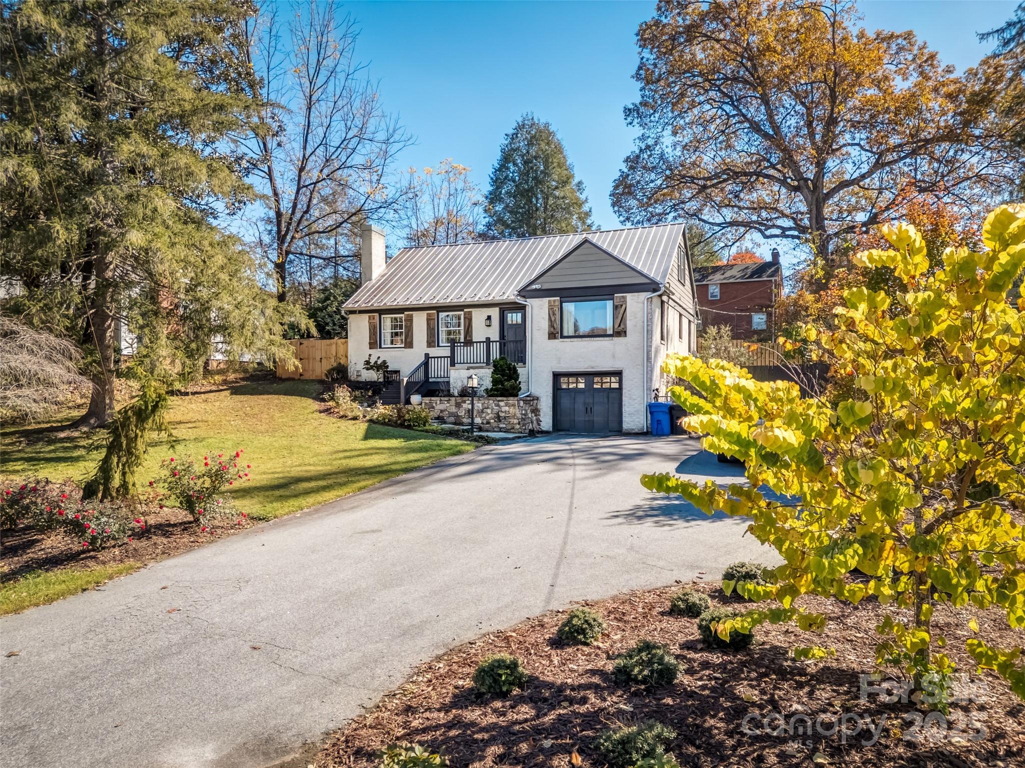 a view of a house with a large tree in front of it