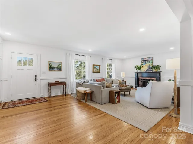 a living room with fireplace furniture and a wooden floor