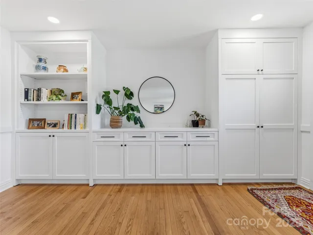 a view of a kitchen with white cabinets and wooden floor