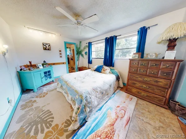 a bedroom with a bed and a ceiling fan