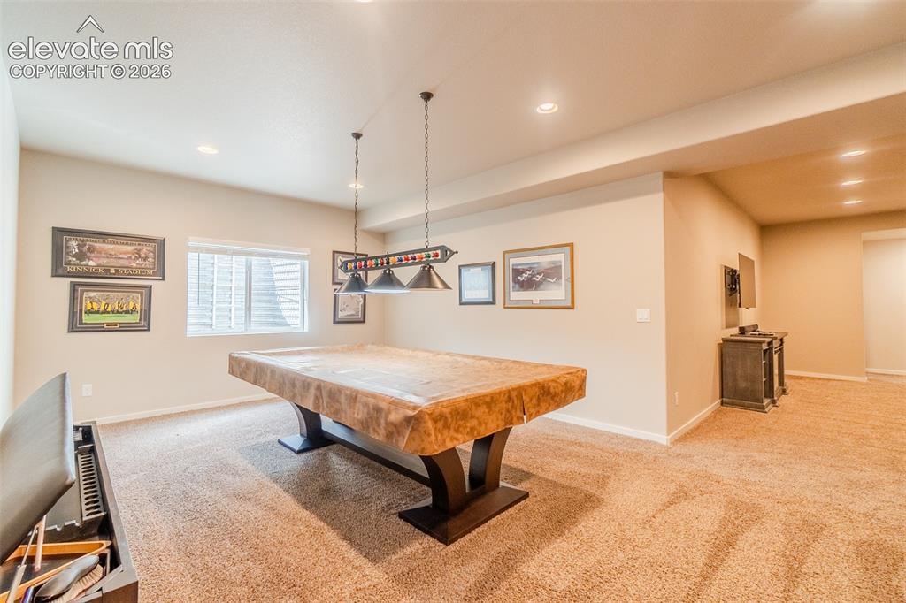 1061 Native Dancer Terrace Colorado Springs, CO 80921 - Photo 36 of 50 Spacious recreation room featuring recessed lighting, a window with blinds, and durable carpet flooring