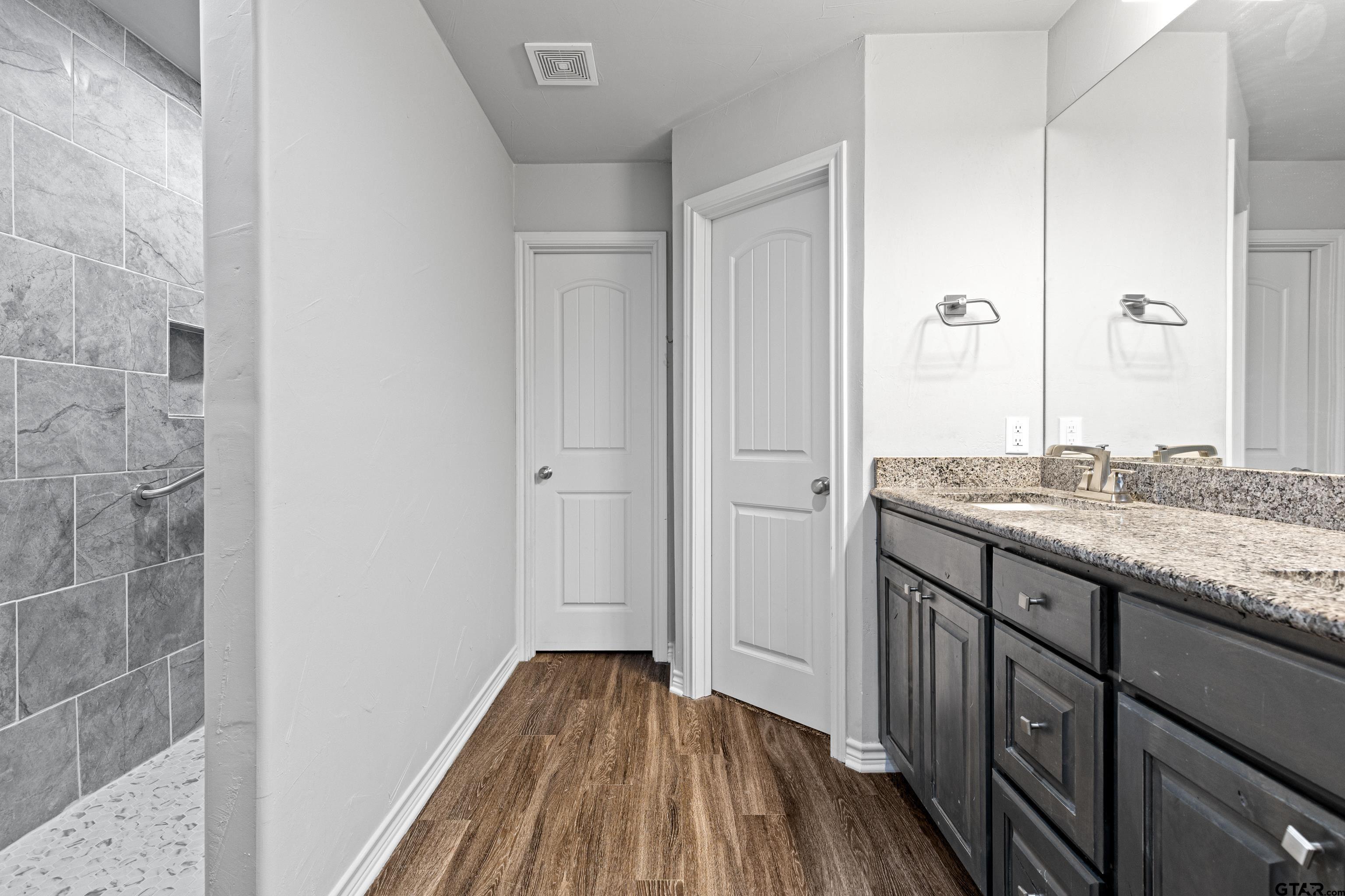 302 Collins Avenue Longview, TX 75605 - Photo 6 of 36 a bathroom with a granite countertop sink and a mirror