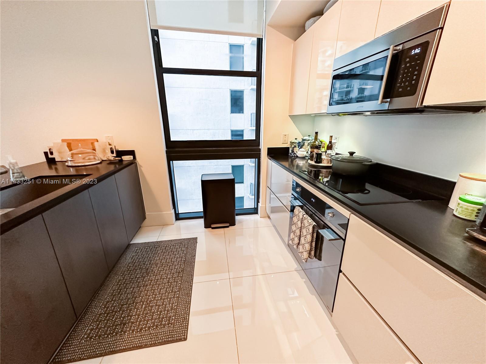 1010 Brickell Avenue, Unit 2505 Miami, FL 33131 - Photo 12 of 38 a kitchen with a sink and a stove