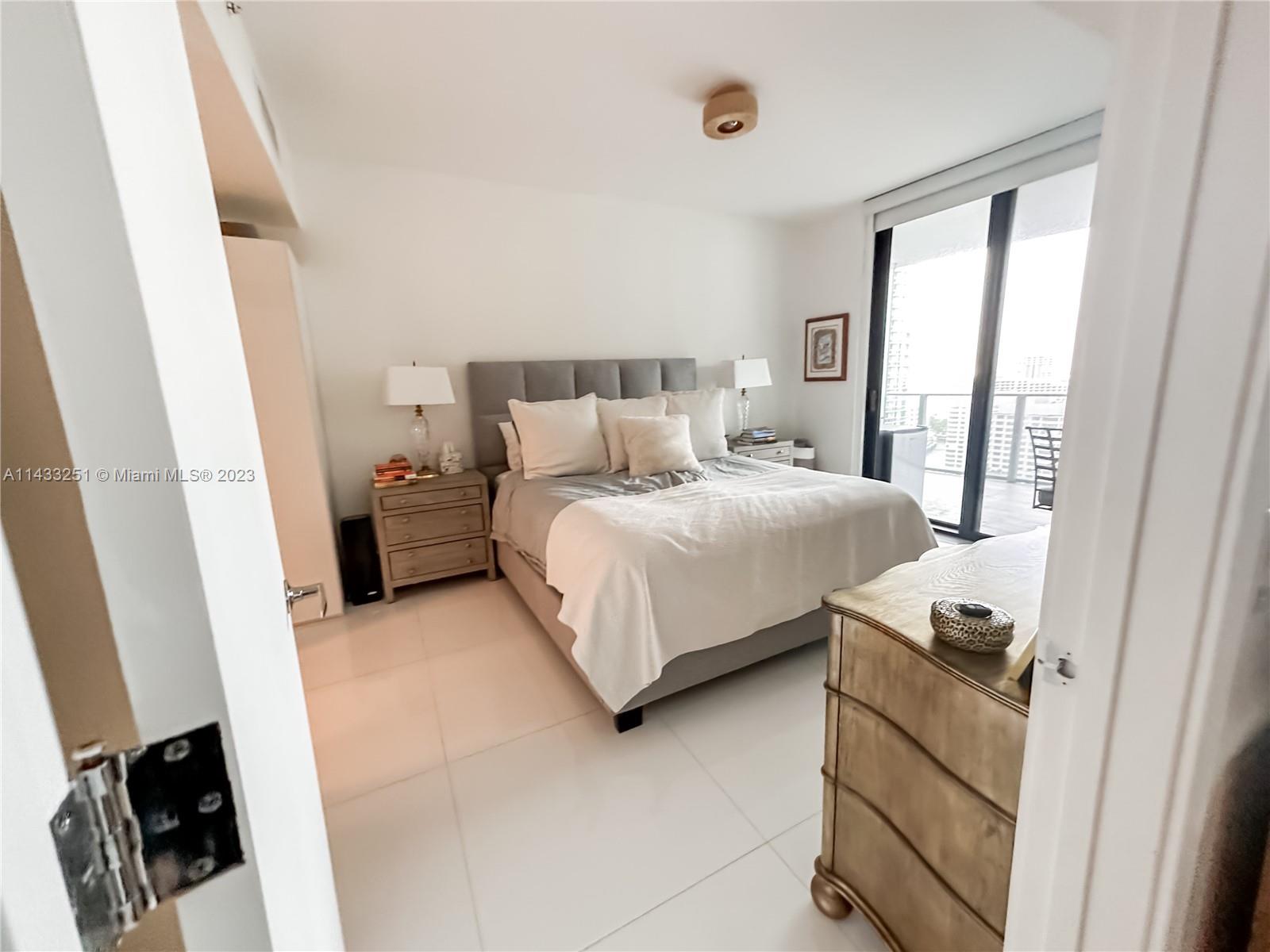 1010 Brickell Avenue, Unit 2505 Miami, FL 33131 - Photo 13 of 38 a bedroom with a bed and wooden floor