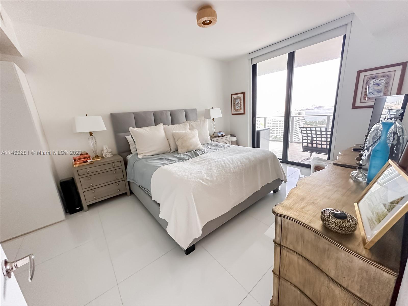 1010 Brickell Avenue, Unit 2505 Miami, FL 33131 - Photo 14 of 38 a bedroom with a bed and a night stand