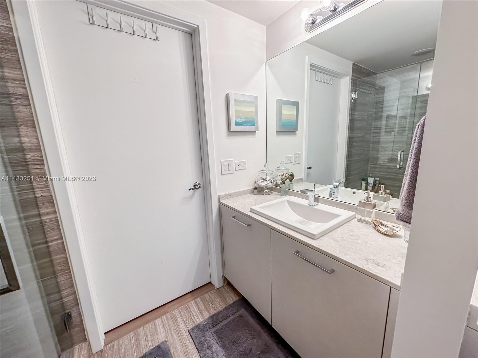1010 Brickell Avenue, Unit 2505 Miami, FL 33131 - Photo 19 of 38 a bathroom with a sink a mirror and a shower