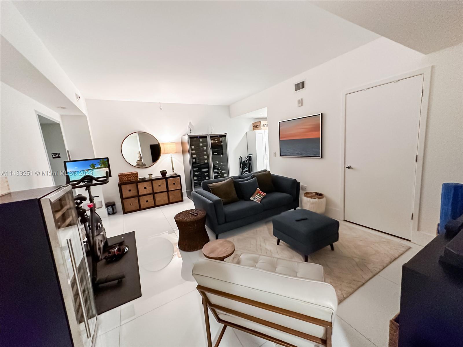 1010 Brickell Avenue, Unit 2505 Miami, FL 33131 - Photo 2 of 38 a living room with furniture and a flat screen tv