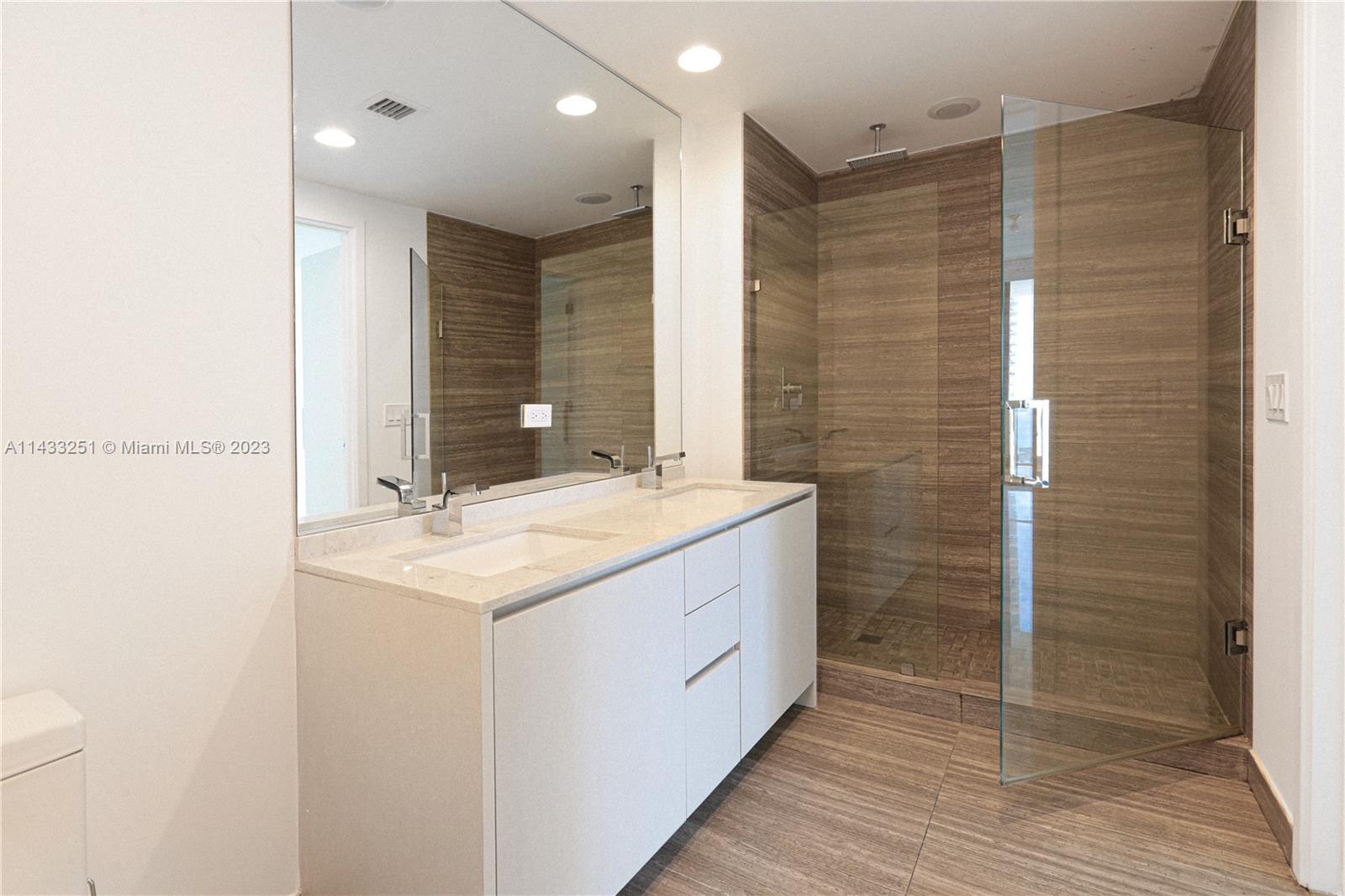 1010 Brickell Avenue, Unit 2505 Miami, FL 33131 - Photo 33 of 38 a bathroom with a shower sink and mirror