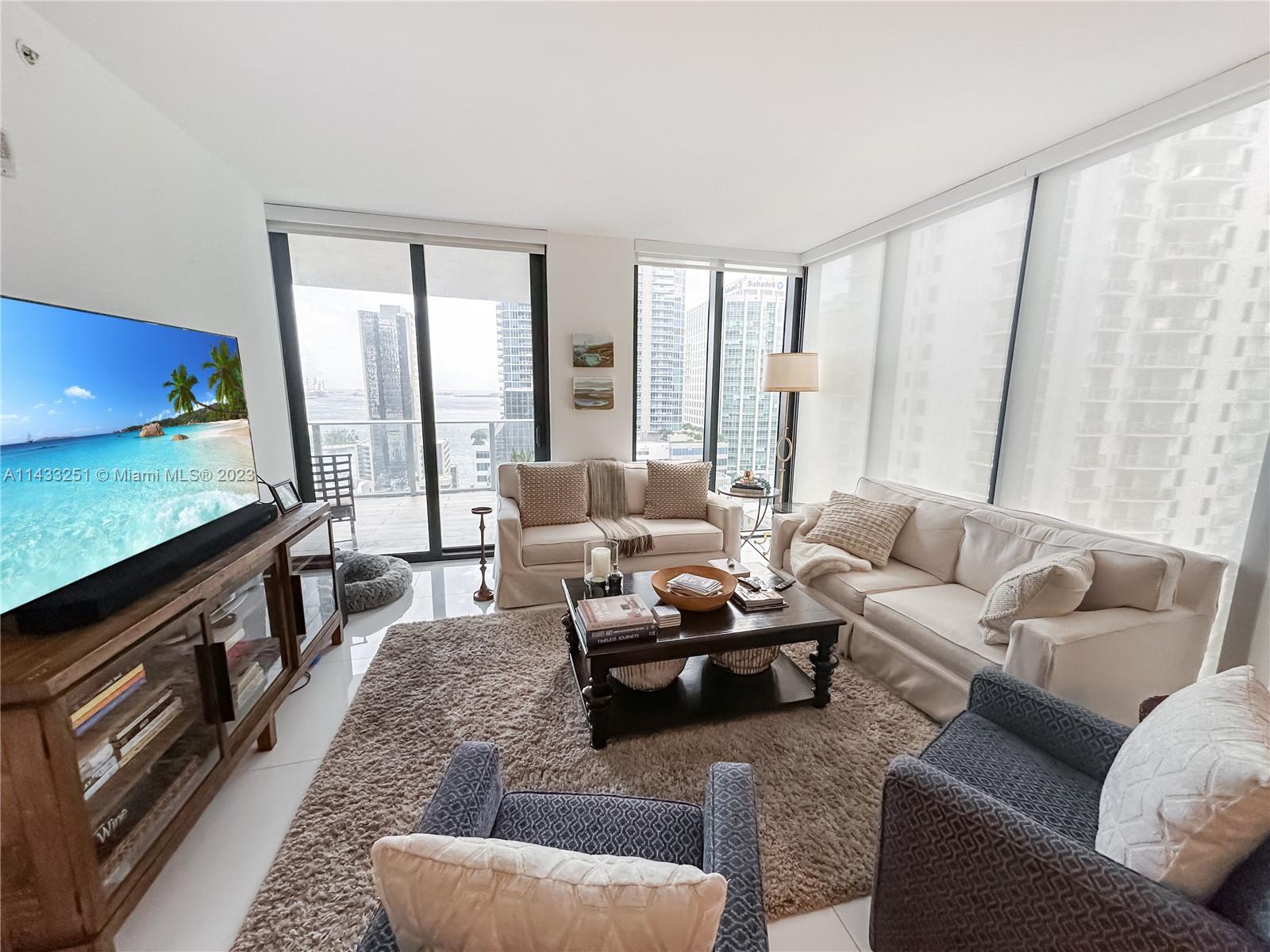 1010 Brickell Avenue, Unit 2505 Miami, FL 33131 - Photo 6 of 38 a living room with furniture and a flat screen tv