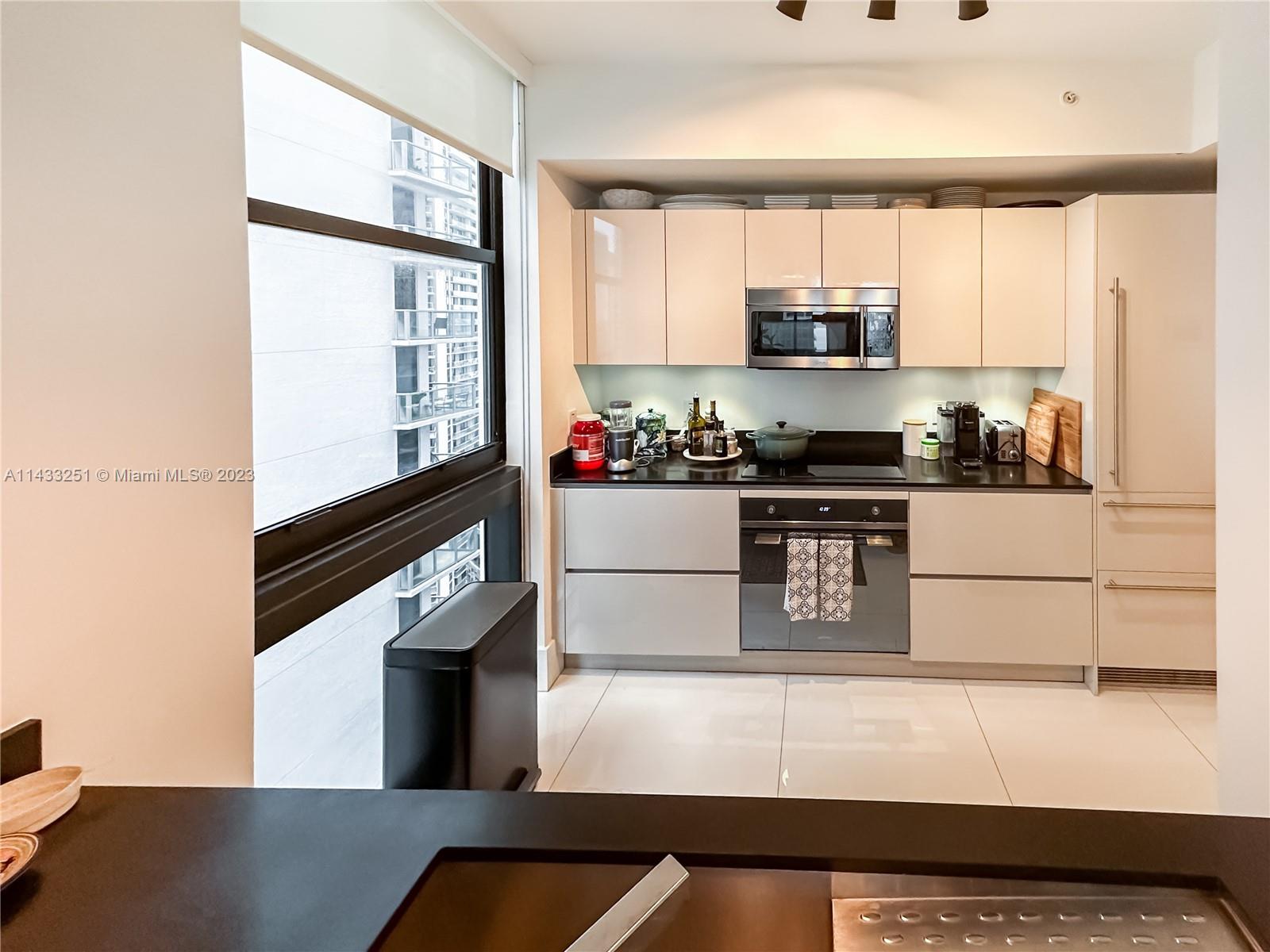 1010 Brickell Avenue, Unit 2505 Miami, FL 33131 - Photo 10 of 38 a kitchen with stainless steel appliances granite countertop a stove a sink and a refrigerator