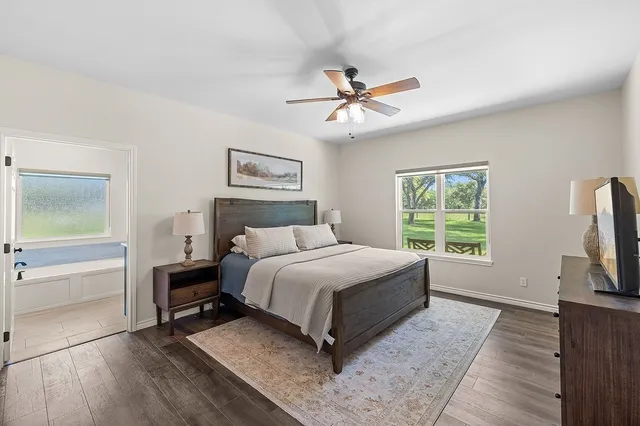 a spacious bathroom with a granite countertop sink mirror and bathtub