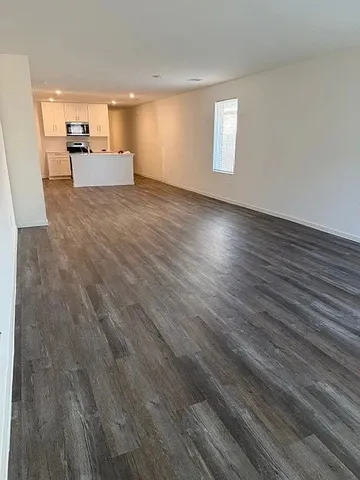 a view of a room with wooden floor and a window