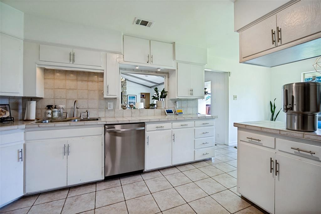 4614 Ridgeside Drive Dallas, TX 75244 - Photo 13 of 30 Kitchen featuring white cabinetry, tile countertops, tile flooring, and a stainless steel dishwasher