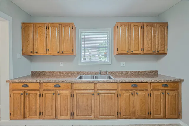 a kitchen with granite countertop cabinets and window