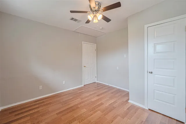 a view of a room with wooden floor and a ceiling fan