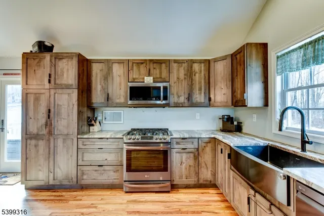 a kitchen with stainless steel appliances granite countertop a refrigerator stove and sink
