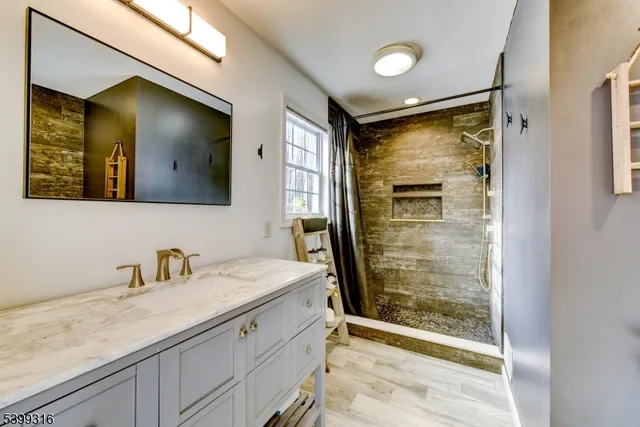 a bathroom with a shower sink and mirror