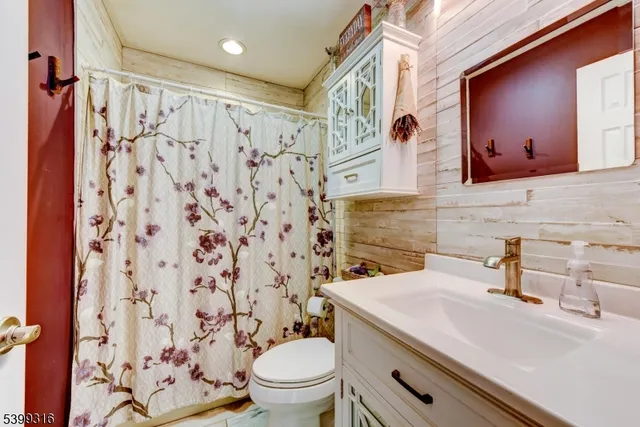 a bathroom with a sink a toilet and shower curtain