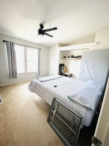 a bedroom with a bed and a large window