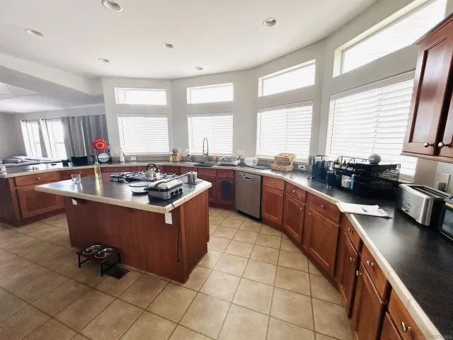 a kitchen with a stove a sink a counter top space and living room