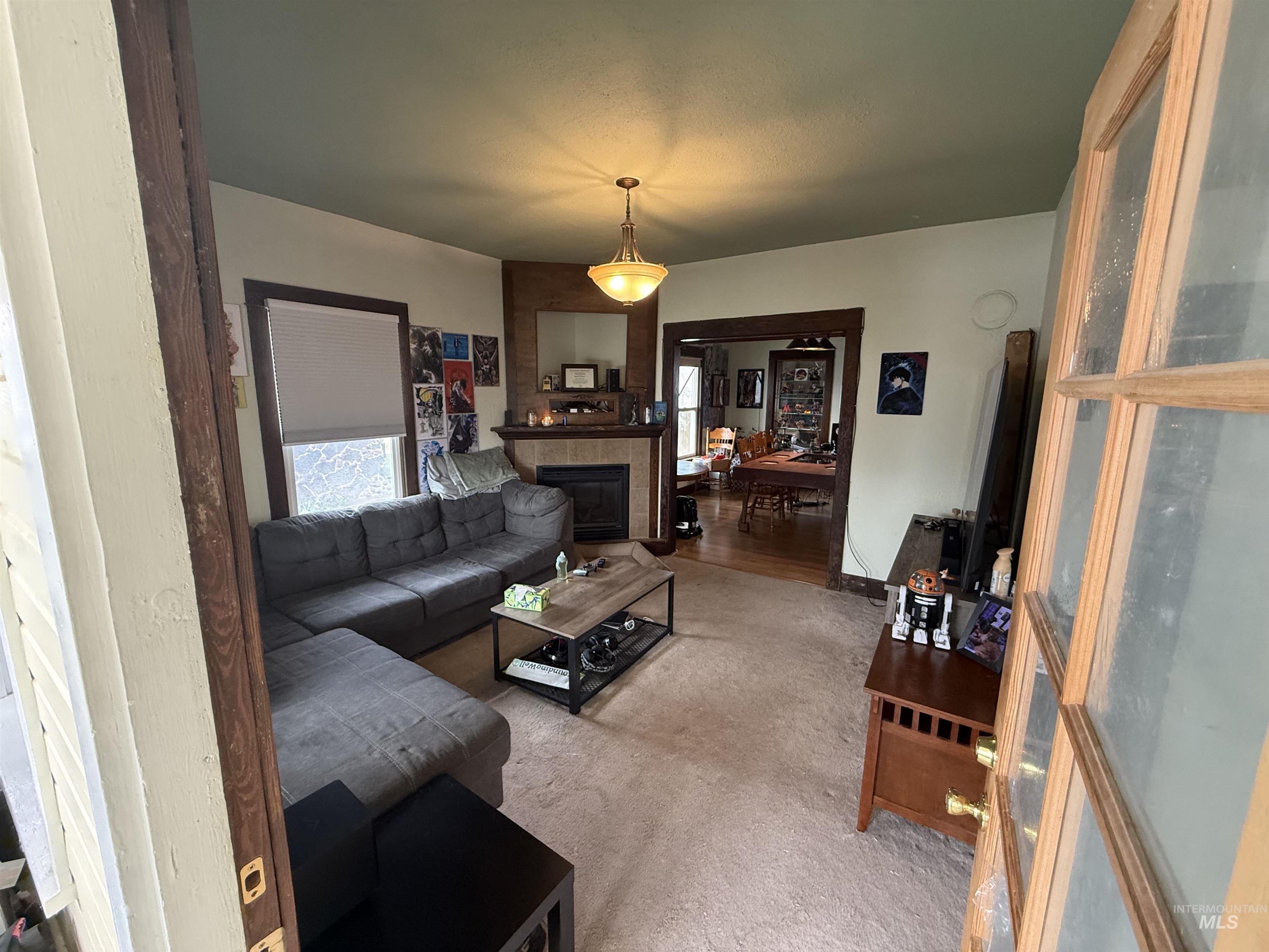 918 5th Street Rupert, ID 83350 - Photo 3 of 14 Carpeted living area featuring a tiled fireplace
