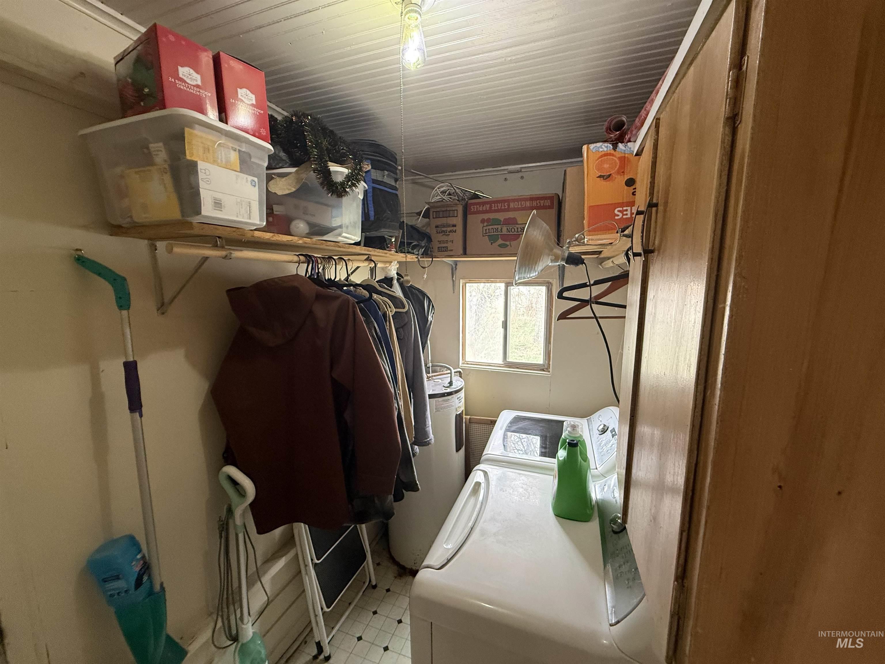918 5th Street Rupert, ID 83350 - Photo 8 of 14 Laundry room with electric water heater, washing machine and clothes dryer, and light flooring