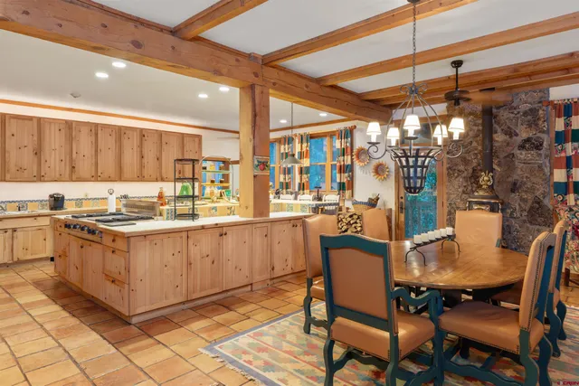 a kitchen with a dining table chairs and white appliances