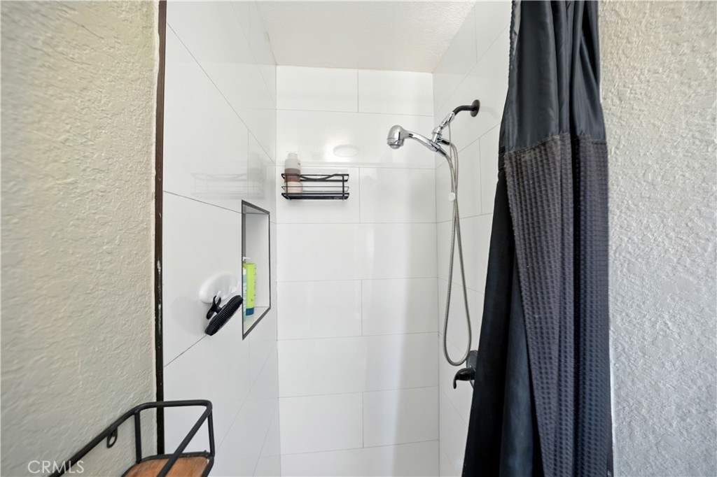 811 West James Street Rialto, CA 92376 - Photo 21 of 43 a bathroom with a shower and a mirror