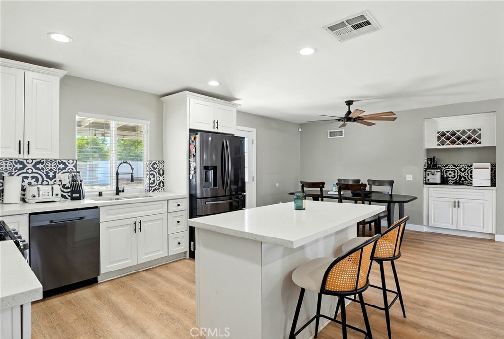 811 West James Street Rialto, CA 92376 - Photo 7 of 43 a kitchen with stainless steel appliances kitchen island granite countertop a sink a stove a refrigerator and island with wooden floor