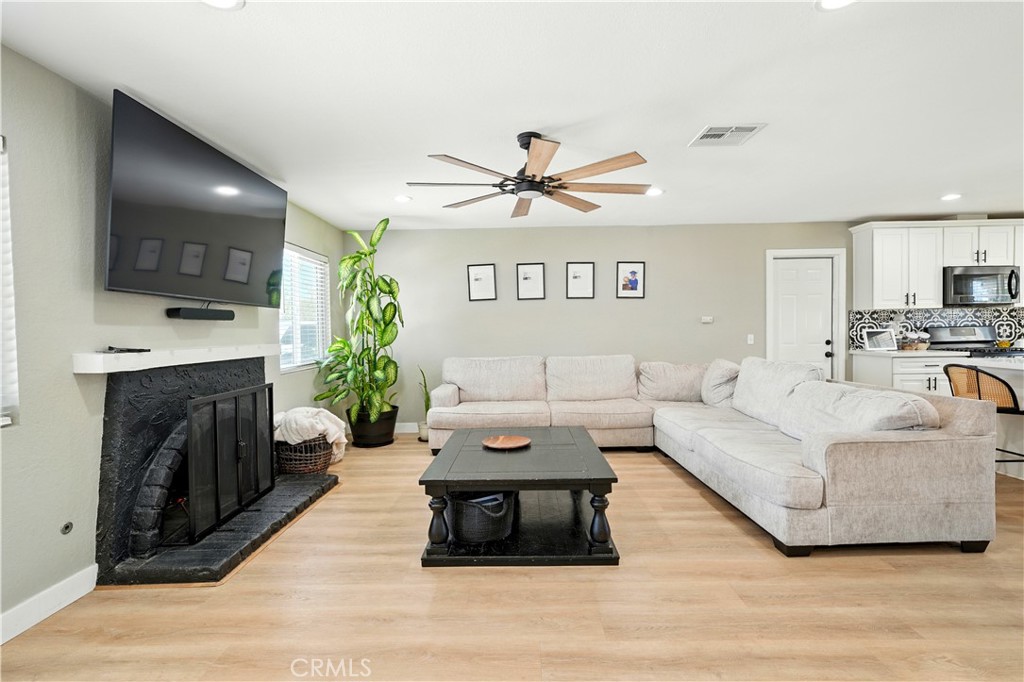 811 West James Street Rialto, CA 92376 - Photo 9 of 43 a living room with furniture a fireplace and a flat screen tv