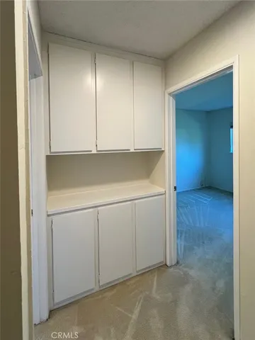 a view of a hallway with wooden shelves