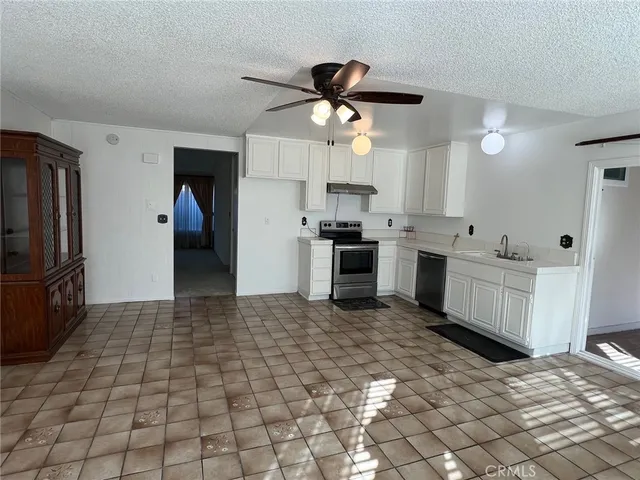 a kitchen with granite countertop a stove a sink and a refrigerator