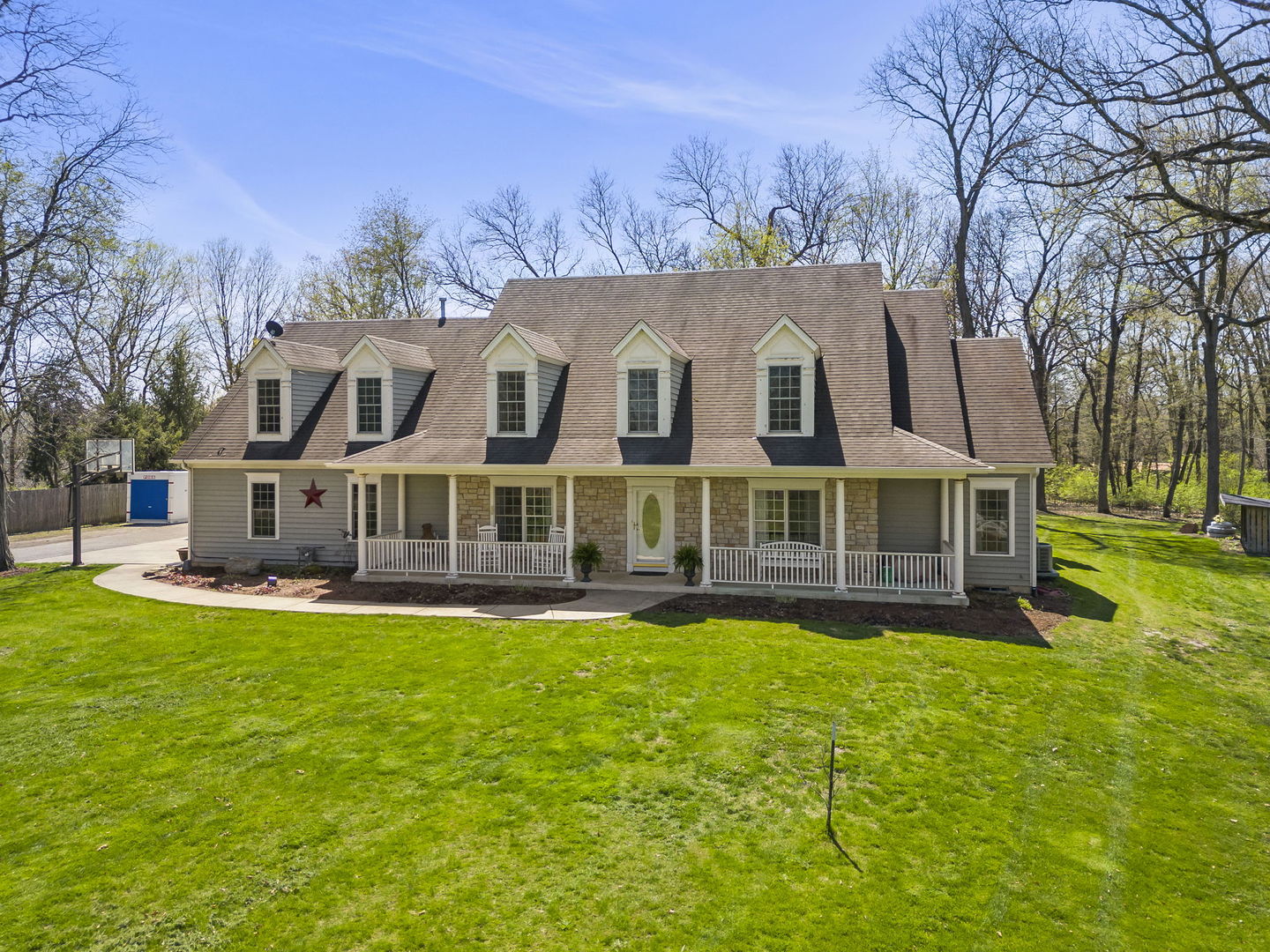 a view of a house with a big yard and large trees
