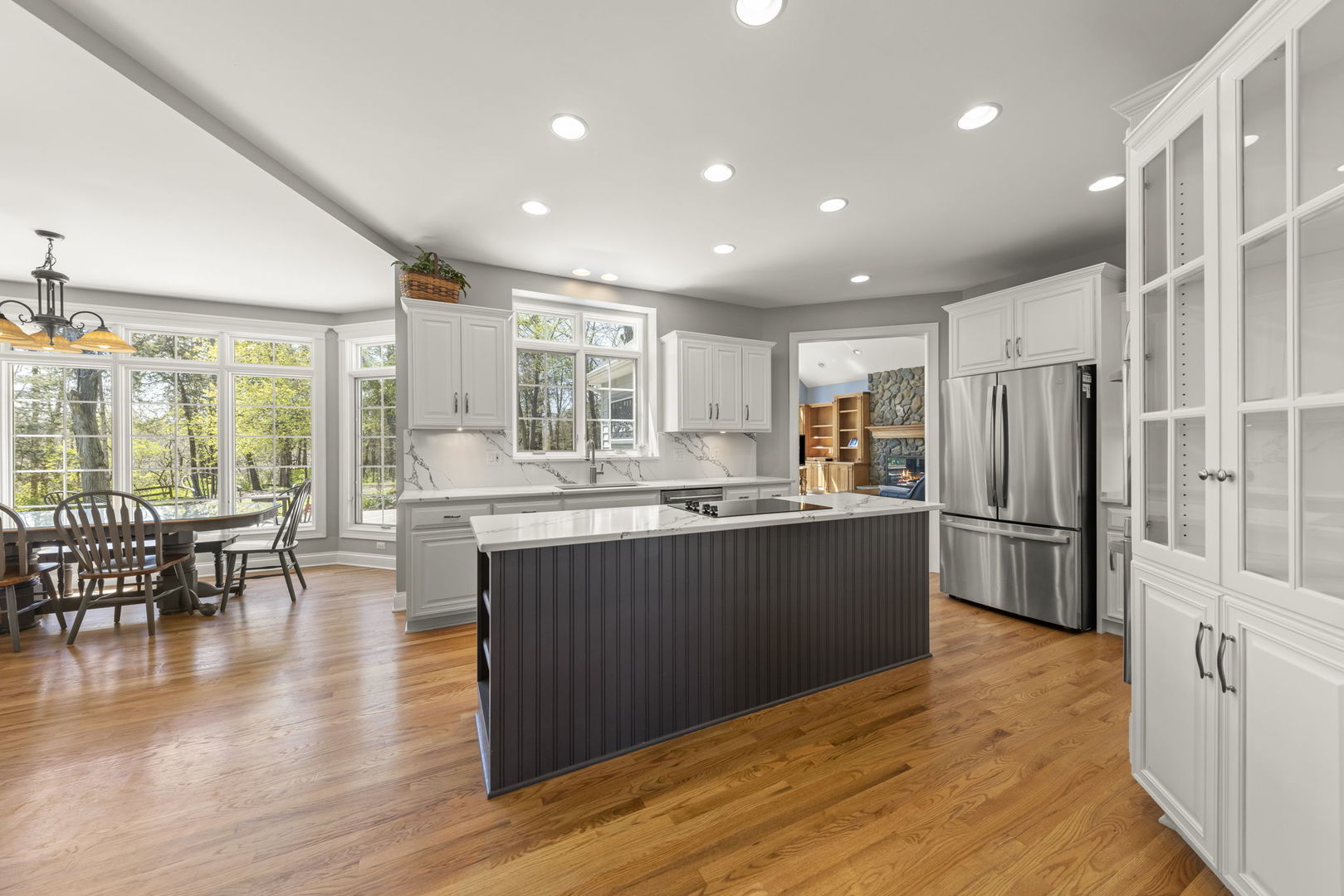 15646 Griswold Springs Road Plano, IL 60545 - Photo 8 of 46 a kitchen with stainless steel appliances granite countertop a refrigerator a stove a sink a dining table and chairs with wooden floor