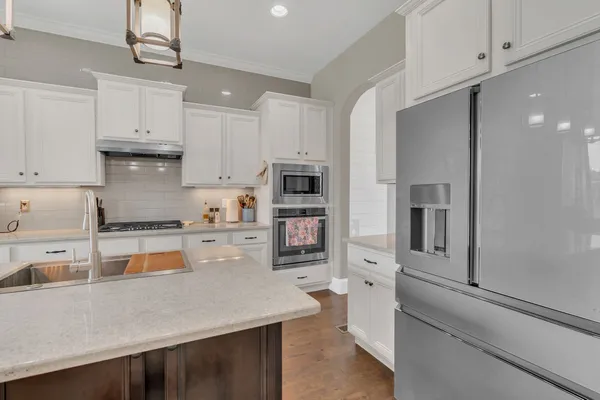 a kitchen with white cabinets and stainless steel appliances