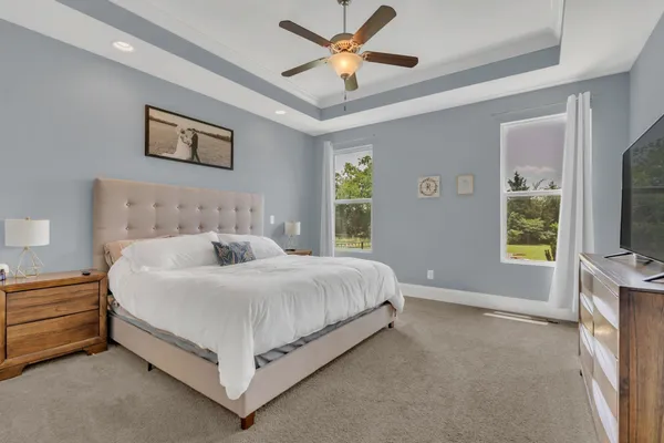 a spacious bedroom with a bed and a flat screen tv