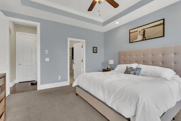 a bedroom with a bed and painting on the wall