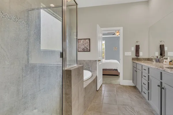 a en suite bathroom with a double vanity sink a mirror and a shower