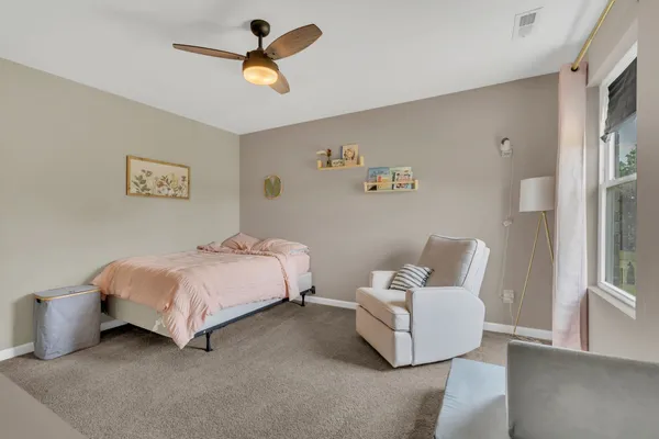 a spacious bedroom with a bed and a ceiling fan