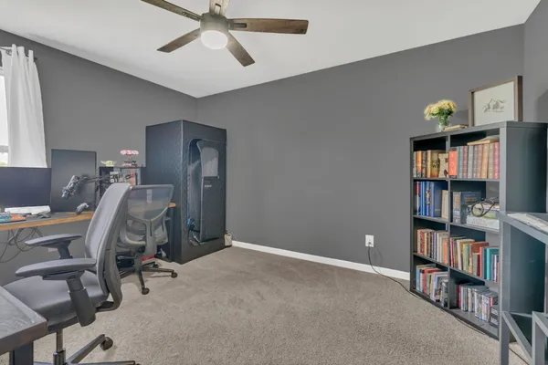 a view of a workspace with furniture and a bookshelf