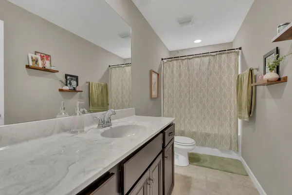 a bathroom with a granite countertop sink toilet and shower