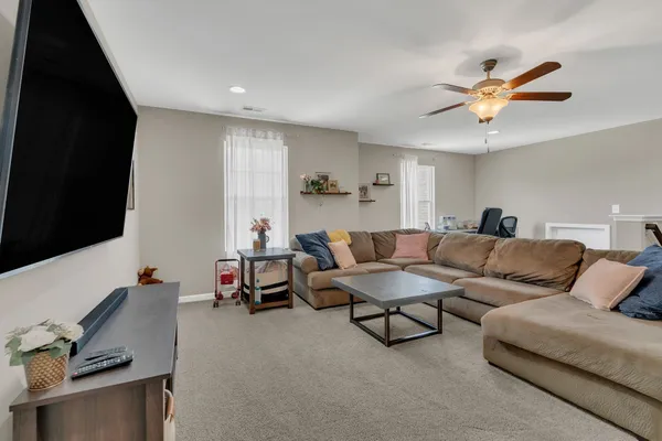 a living room with furniture and a flat screen tv with kitchen view