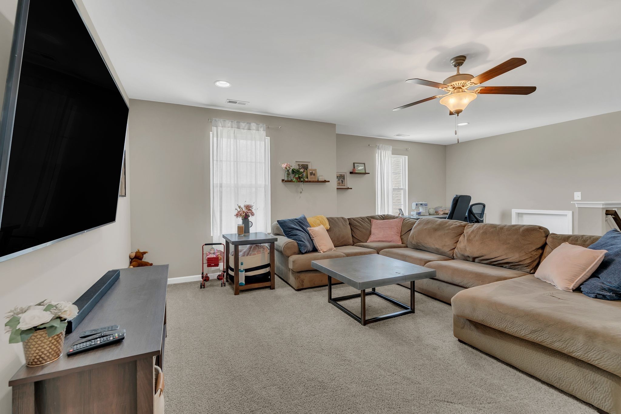 7121 Springwater Street Smyrna, TN 37167 - Photo 26 of 33 a living room with furniture and a flat screen tv with kitchen view