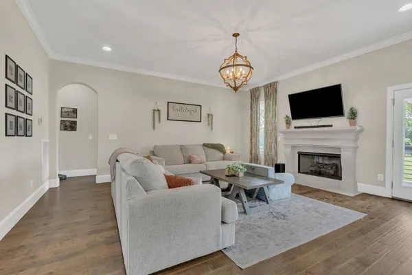 a living room with furniture a flat screen tv and a fireplace