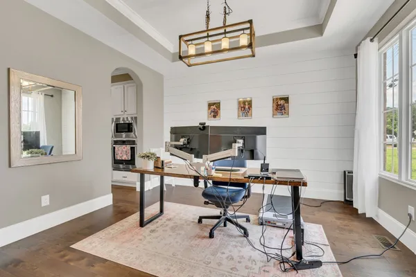 a view of a workspace with furniture and a window