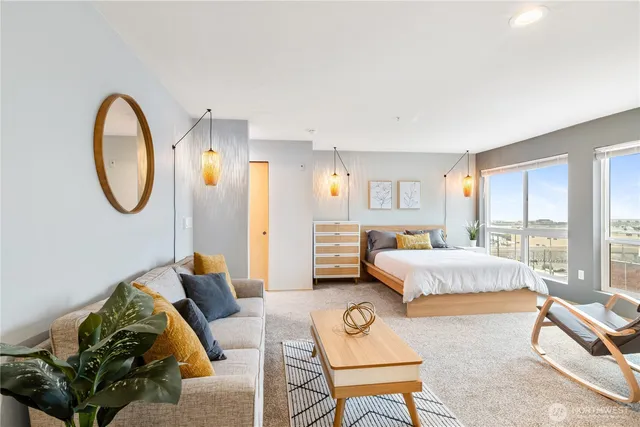 a spacious bedroom with a bed a couch and dresser